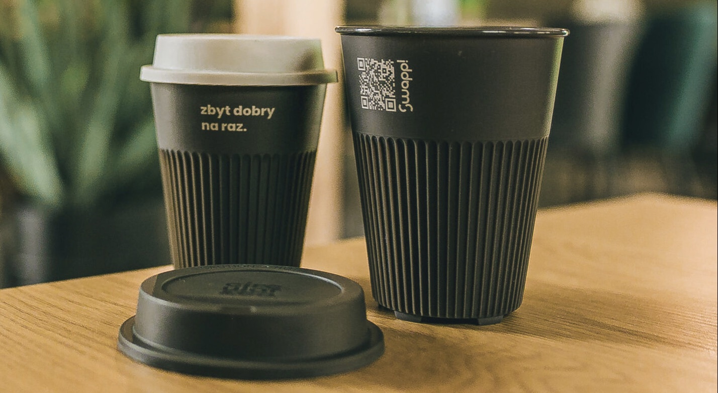 A close-up shot of black, reusable food containers from Swapp! with a visible QR  code for tracking.